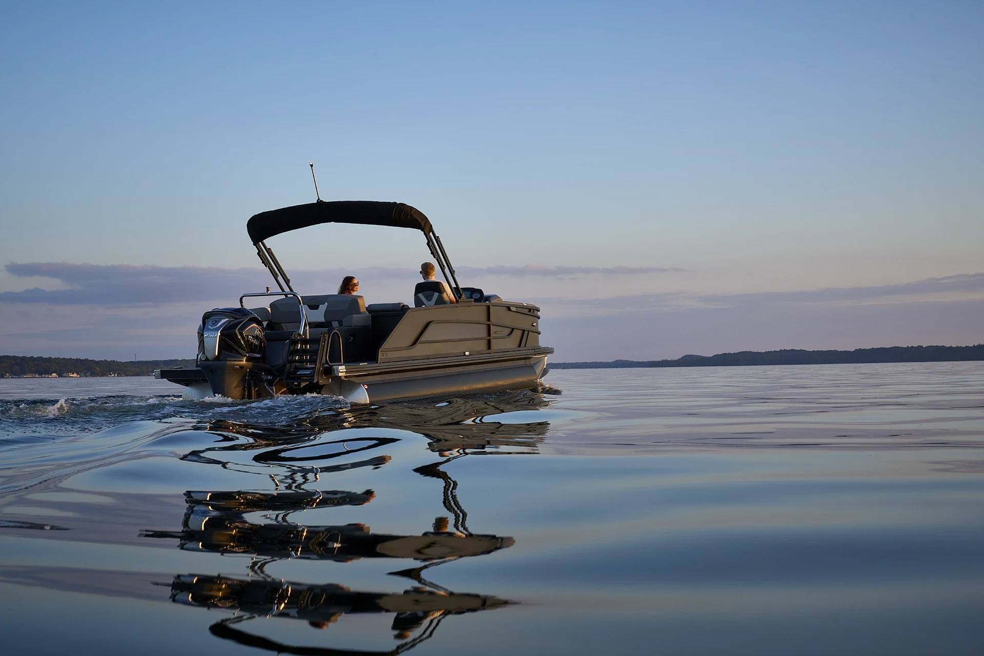 Evotti 500 Series 23CS cruising on calm water at dusk