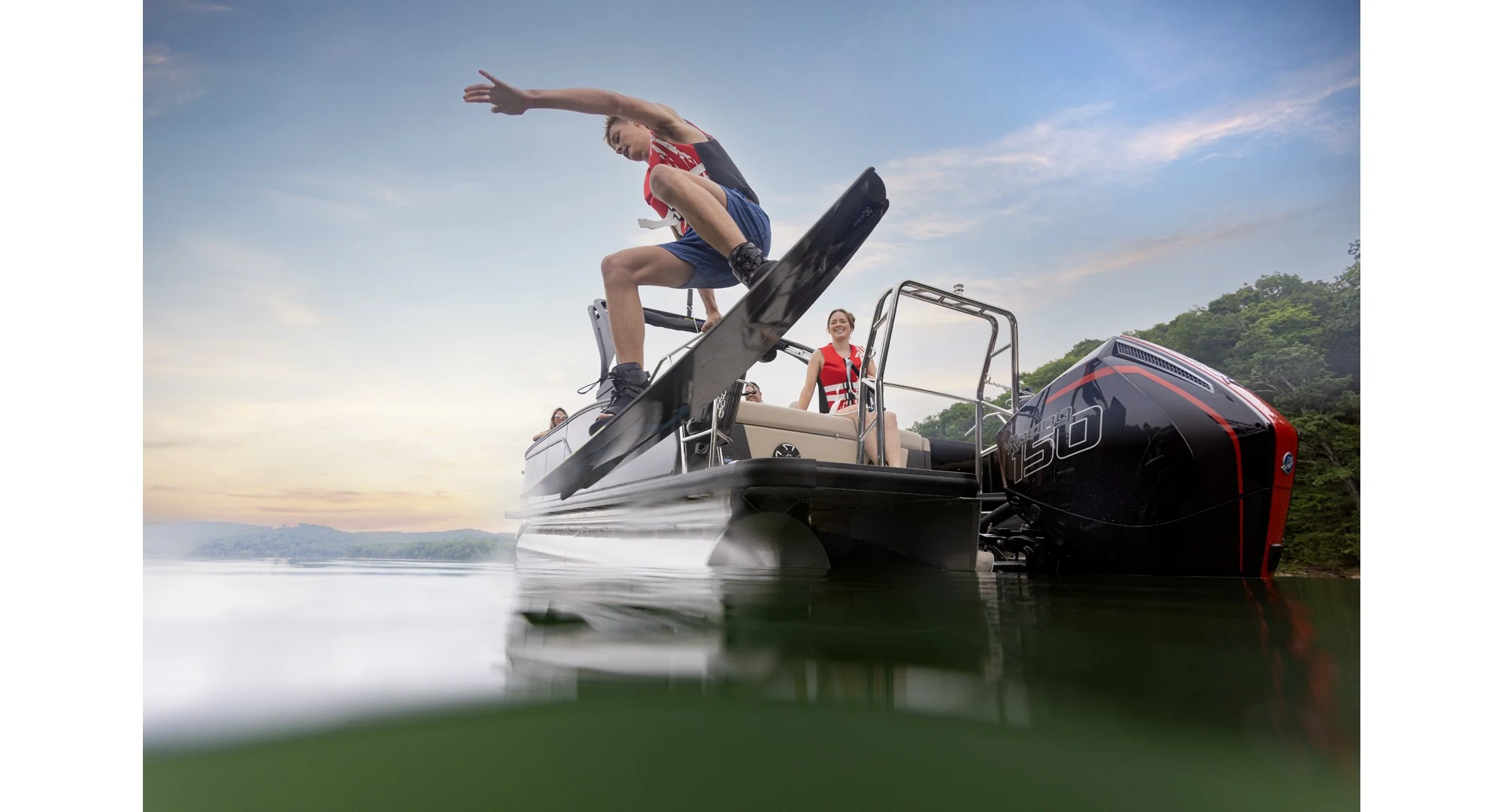 Wakeboarder riding behind a Harris Sunliner on open water