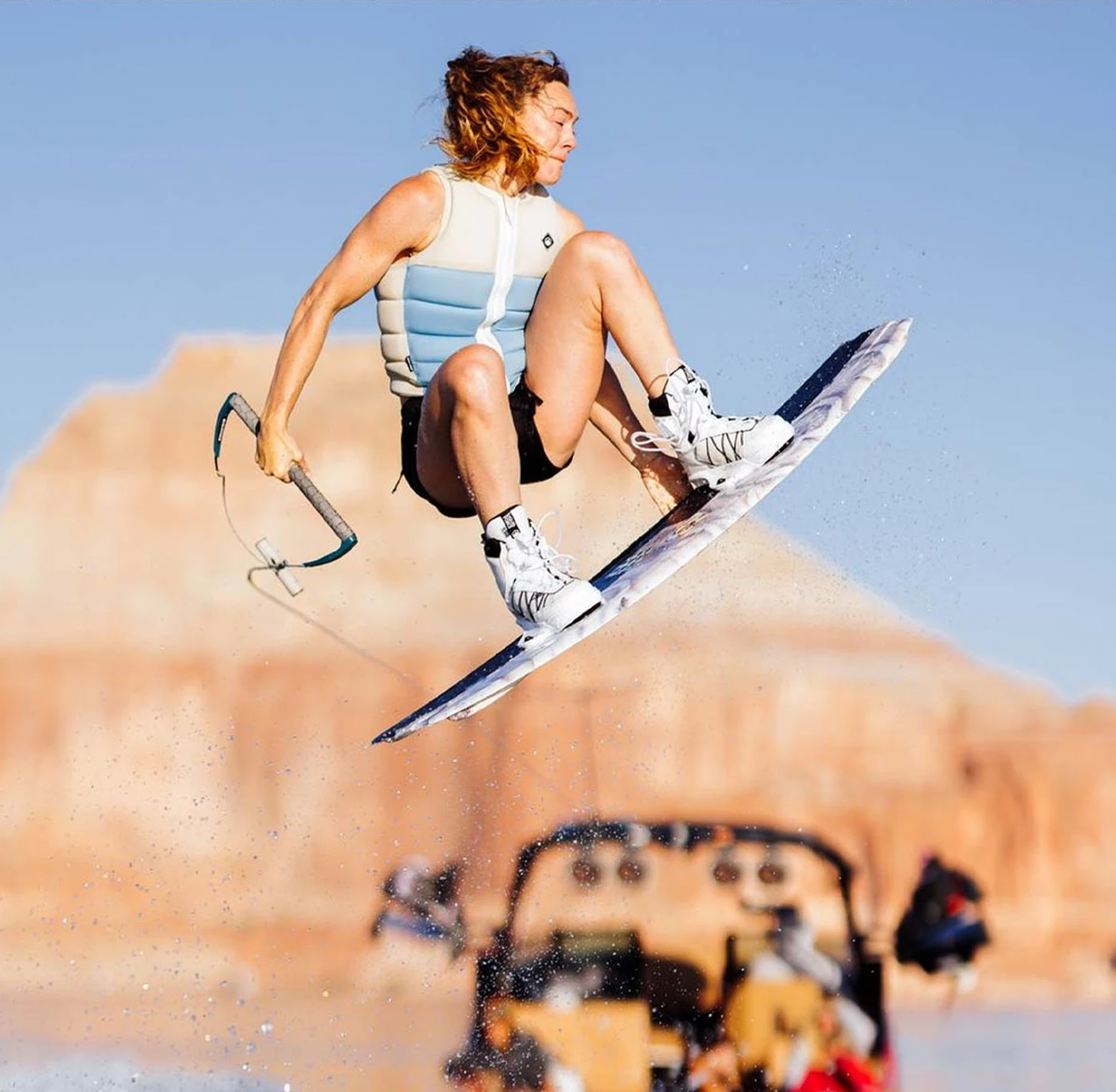 Liquid Force wakeboard rider airborne above the lake